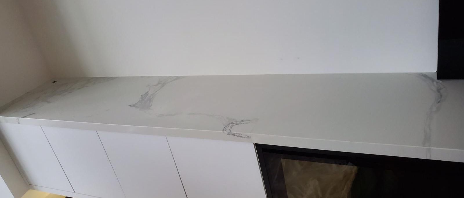 White veined stone ledge over a linear fireplace