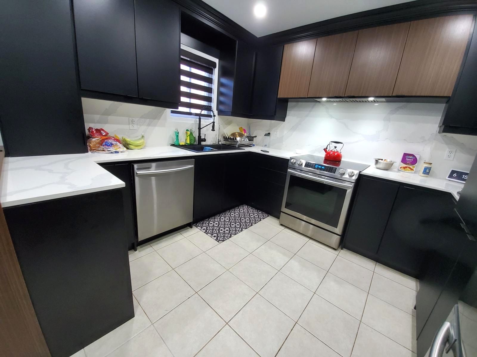 Kitchen countertops with a matching full-height backsplash and dark cabinets