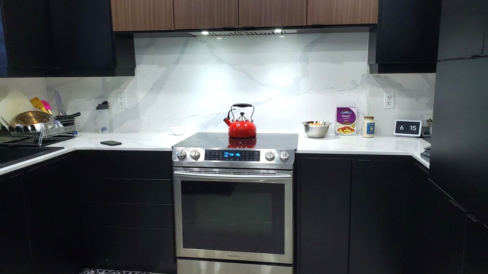 U-shaped kitchen with white countertops and a full-height veined stone backsplash, installed by Nexus Stone